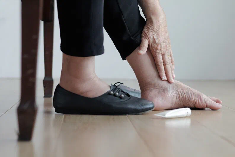 A person checking their foot by hand